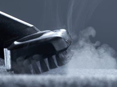 Home cleaning. Steam carpet cleaning on a grey background. Photo from copy space. Carpet Cleaning service Cambridge